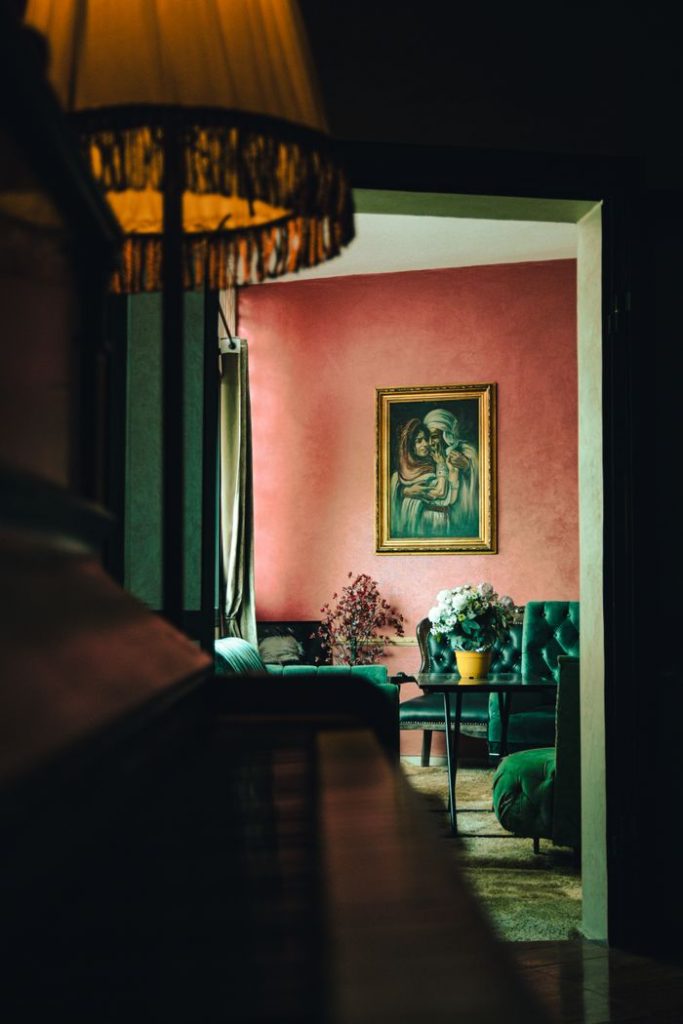 Warm vintage interior of a room in Meknes, Morocco, featuring a framed painting and elegant seating.