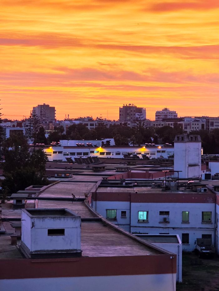 Vibrant sunset over Casablanca's skyline with colorful hues reflecting off the urban landscape.